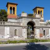 Il monumentale ingresso si trova al civico 176 della trafficata via: un arcone a tutto sesto, delimitato da semicolonne binate...